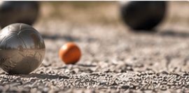 Boule-Kugeln mit orangener Zielkugel auf Kies